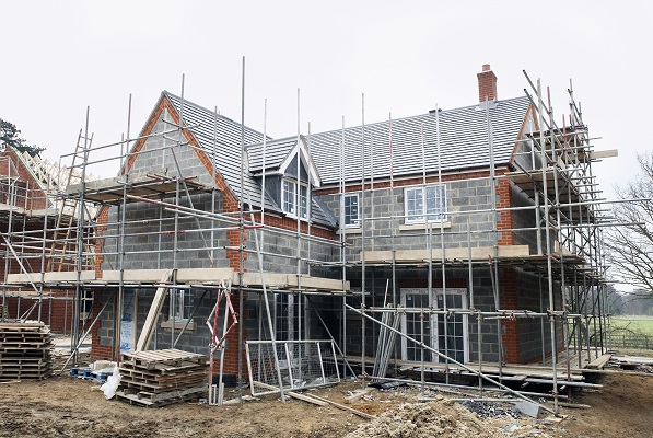 Large new build house with scaffolding, UK.